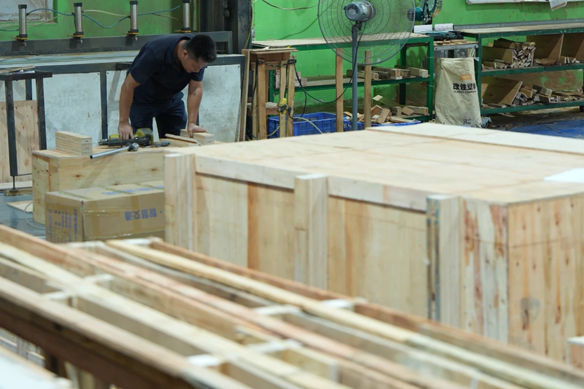 Ein Teammitglied fertigt Verpackungskisten aus Holz