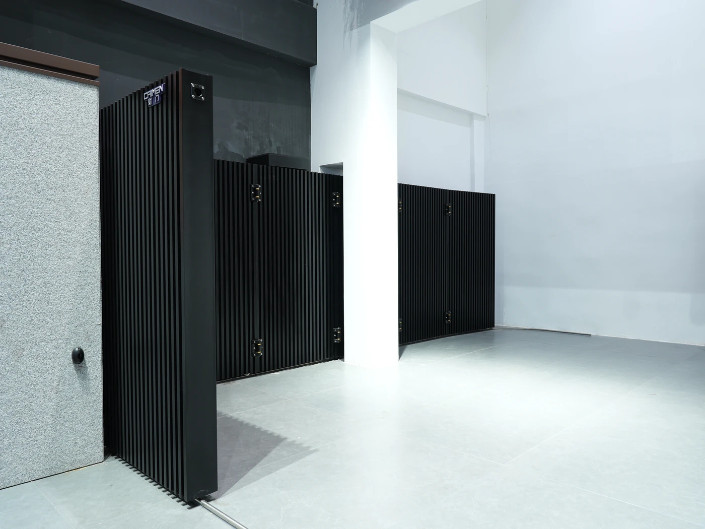 Sectional sliding gate panels following a corner in the CAIMEN showroom.