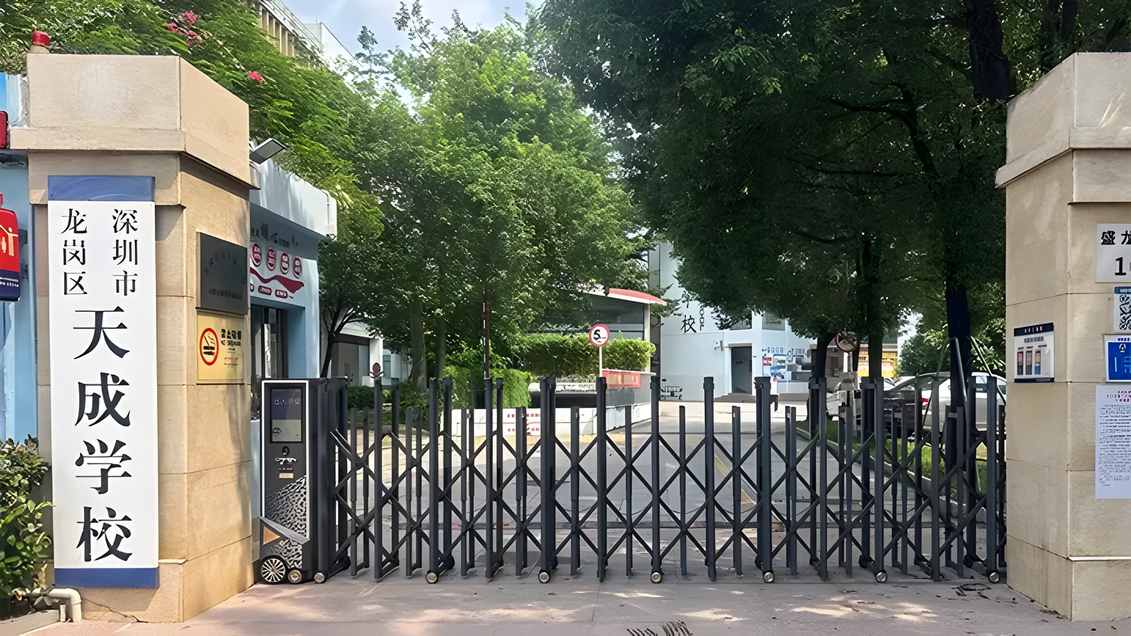 Retractable gate controlling a tree-lined campus entrance